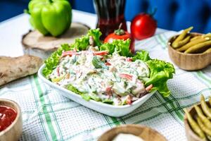 tavolo con ciotole di fresco insalata foto