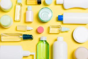 gruppo di plastica cura del corpo bottiglia piatto posare composizione con cosmetico prodotti su giallo sfondo vuoto spazio per voi design. impostato di bianca cosmetico contenitori, superiore Visualizza con copia spazio foto