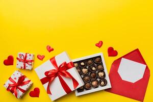 Busta su colorato sfondo per San Valentino giorno con regalo scatola e cioccolato. cuore sagomato con regalo scatola di cioccolatini superiore Visualizza con copia spazio foto