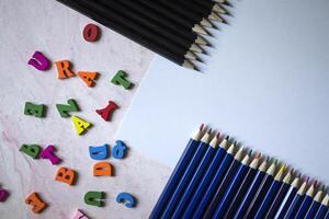 multicolore lettere e impostato di matite su il tavolo. colorato di legno alfabeto e matite su un' tavolo. foto