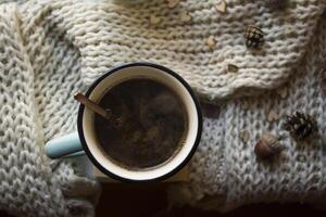 un' tazza di caffè e di lana sciarpa con decorazioni su un' tavolo. intimità. foto