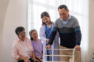 asiatico giovane infermiera supporto anziano più vecchio uomo camminare con camminatore. bellissimo infermiera Aiuto e prendere cura. anziano maturo Nonno paziente fare fisico terapia con un' gruppo di anziano amici nel Ospedale. foto