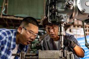 asiatico lavoratore nel produzione pianta perforazione a macchina. professionale lavoratore vicino perforazione macchina su fabbrica. finitura metallo Lavorando interno acciaio superficie su tornio macinino macchina con volante scintille. foto