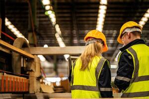 indietro di fabbrica ingegnere lavoratori in piedi per controllo pannello interruttore. persone lavori a pesante macchina a industria fabbrica. con macchinari attrezzatura pianta tecnologia. inteligente industria lavoratore operativo. foto