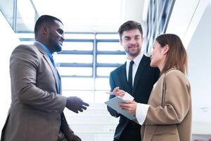 attività commerciale persone tremante mani. finitura su un' incontro. squadra di attività commerciale persone camminare nel corsa ora a interno pedone le scale e parlare insieme. concetto negoziati nel sensazione riuscito e contento. foto