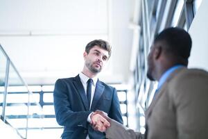 attività commerciale persone tremante mani. finitura su un' incontro. squadra di attività commerciale persone camminare nel corsa ora a interno pedone le scale e parlare insieme. concetto negoziati nel sensazione riuscito e contento. foto