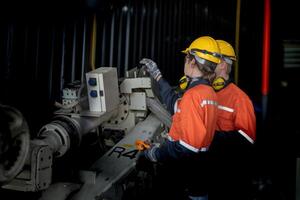 maschio ingegnere lavoratori Manutenzione automatico robotica braccio macchina nel un' fabbrica. lavoratore controllo e riparazione automatico robot mano macchina. tecnico lavoratore dai un'occhiata per riparazione fabbrica macchina. foto