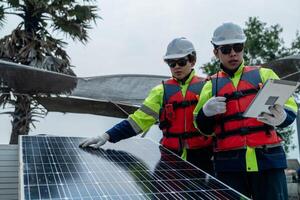 ingegnere uomini ispezionare moduli di fotovoltaico cellula pannelli. industriale rinnovabile energia di verde potenza. lavoratori preparare materiale prima costruzione su luogo con il pila di pannelli a sfondo. foto