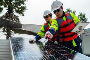 ingegnere uomini ispezionare moduli di fotovoltaico cellula pannelli. industriale rinnovabile energia di verde potenza. lavoratori preparare materiale prima costruzione su luogo con il pila di pannelli a sfondo. foto