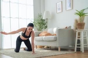 vicino su donne fiducioso formazione yoga. atletico donne nel abbigliamento sportivo fare fitness allungamento esercizi a casa nel il vivente camera. sport e ricreazione concetto. yoga insegnante è porzione ragazza. foto