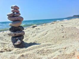 un' gruppo di mare pietre su il sabbia vicino mare. foto