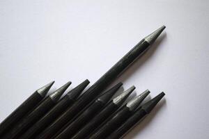 il impostato di grigio matite su un' bianca sfondo. utensili per disegno su il scrivania. foto