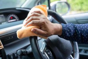 nuova normale donna lavoratrice asiatica pulita in auto per proteggere la sicurezza del coronavirus. foto