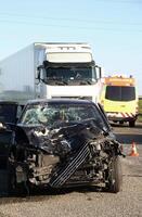 collisione luogo su un' asfalto strada con danneggiato auto nel davanti di camion foto