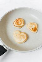 fritte Pancakes nel un' frittura padella su un' bianca sfondo, superiore Visualizza foto