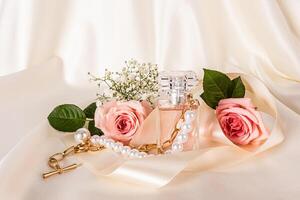 elegante bottiglia di Da donna profumo tra beige raso nastro, rosa Rose su tessuto raso sfondo. oro collana con perle. profumo e bellezza concetto. foto