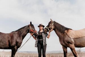 giovane contento donna nel cappello con sua cavallo nel sera tramonto luce. all'aperto fotografia con moda modello ragazza. stile di vita umore. concetto di all'aperto cavalcare, gli sport e ricreazione. foto