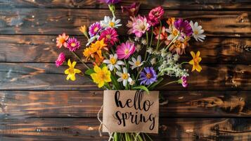 ai generato nostro 'ciao primavera' iscrizione impostato contro un' fondale di vivace fiori cattura il essenza di il stagione. foto