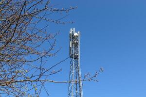 elettrico antenna e comunicazione trasmettitore Torre nel un' settentrionale europeo paesaggio contro un' blu cielo foto