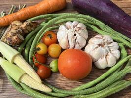 verdure pomodori carote e altro su di legno tavolo vicino su fotografato a partire dal sopra foto