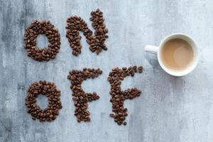 tazza di caffè come un' interruttore fra su e via fagioli, grigio pietra sfondo, mattina o veglia su concetto foto