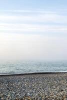 paesaggio marino Visualizza di natura su il costa di un' spiaggia e oceano acqua su un' estate giorno. bellissimo scenario di un' mare riva pieno con roccioso sabbia textures e il blu cielo su il orizzonte e nebbia. foto