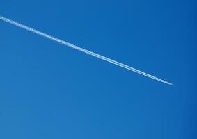 aereo condensazione pista e aereo su blu cielo foto