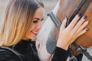 giovane donna fisioterapista assunzione cura un' Marrone cavallo. donna fabbricazione un' trattamento nel il spalla, cresta, fronte, museruola e mento scanalatura. foto