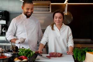 bello giovane africano capocuoco è cucinando insieme con il suo caucasico fidanzata nel il cucina utilizzando rosso vino come un ingrediente. foto