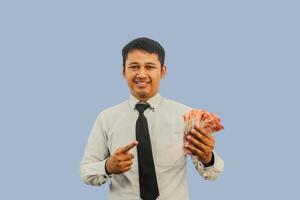 adulto asiatico uomo sorridente e mostrando fiducioso quando puntamento per carta i soldi quello lui hold foto