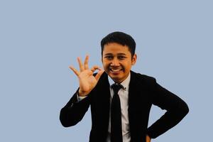 adulto asiatico uomo sorridente amichevole mentre dando ok dito cartello foto