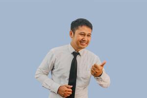 adulto asiatico uomo lato Visualizza sorridente contento con il suo pollice puntamento per il giusto lato foto