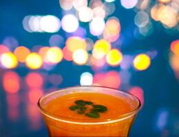 arancia succo nel bar bicchiere nel davanti di sfocato lampeggiante luci sfondo foto