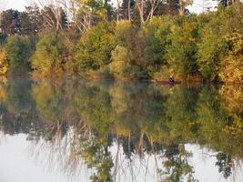 barca e fiume nel autunno con colorato alberi foto