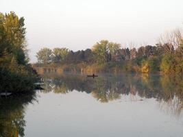 barca e fiume nel autunno con colorato alberi foto