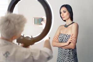 trucco artista bsn fotografie su un' mobile Telefono il risultato di il suo opera su un' bellissimo ragazza modello con un' squillare leggero lampada