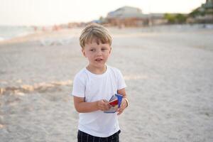 caucasico ragazzo in piedi spiaggia. infanzia estate. famiglia vacanza foto