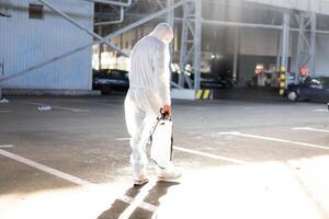 uomo vestito bianca protettivo tuta da lavoro spruzzatura superficie antibatterico disinfettante spruzzatore durante quarantena foto