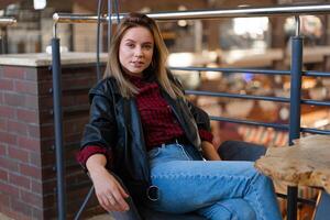 giovane bellissimo elegante moderno ragazza seduta a un' tavolo nel un' bar in attesa per amici dopo shopping foto