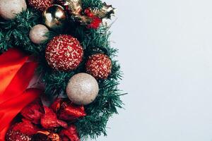 Natale decorativo ghirlanda di agrifoglio, edera, vischio, cedro e leyland foglia rametti con rosso frutti di bosco al di sopra di bianca sfondo. foto