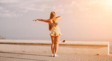 donna estate danza. silhouette di un' contento donna chi balli, gira e solleva sua mani per il cielo. un' giocoso giovane donna gode sua contento momento danza nel il raggi di il d'oro sole. foto