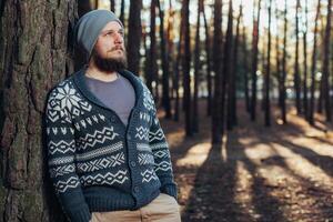 un' giovane uomo con un' barba passeggiate nel un' pino foresta. ritratto di un' brutale barbuto uomo autunno foresta foto