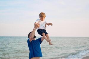 padre figlio la spesa tempo insieme mare vacanza giovane papà bambino poco ragazzo a piedi spiaggia foto