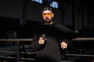 bello giovane con la barba lunga uomo nero felpa con cappuccio e bandana sta foto