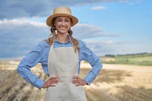 donna contadino cannuccia cappello grembiule in piedi terreni agricoli sorridente femmina agronomo specialista agricoltura agribusiness contento positivo caucasico lavoratore agricolo campo foto