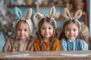 ai generato tre carino poco ragazze siamo indossare coniglietto orecchie mentre seduta a il tavolo su Pasqua giorno. foto