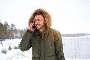 attraente barbuto uomo in piedi all'aperto nel inverno stagione foresta. foto