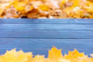 vuoto di legno tavolo natura bokeh sfondo con autunno giallo acero foglia pensionante modello finto su per Schermo di Prodotto copia spazio foto