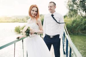 sposa e sposo siamo in piedi su il ponte foto