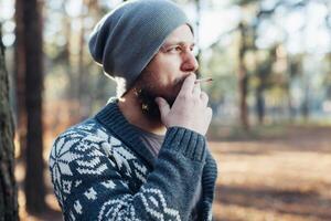 un' giovane uomo con un' barba passeggiate nel un' pino foresta. ritratto di un' brutale barbuto uomo autunno foresta foto